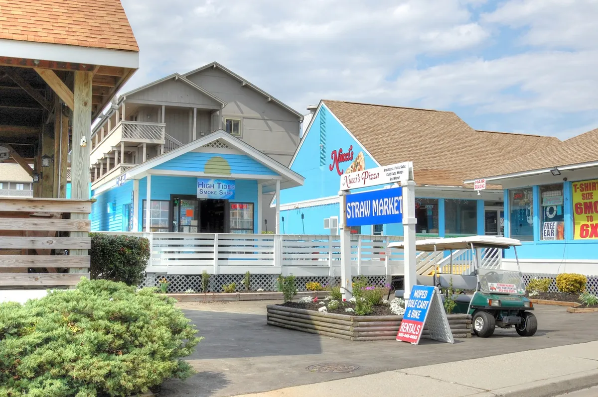 A vibrant streetscape featuring colorful buildings, local business signs, and a golf cart, this image captures the lively yet relaxed local scene. The area is inviting for shopping, dining, and discovering nearby attractions—perfect for extended-stay guests exploring the quieter side of Myrtle Beach in winter.